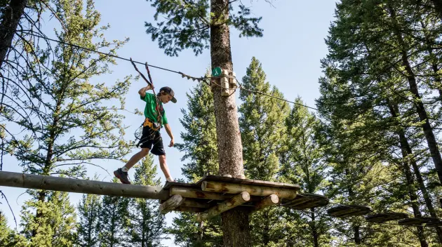 Traveler walking on a high ropes course