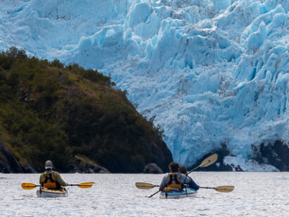 Kayakers in front of a glacier