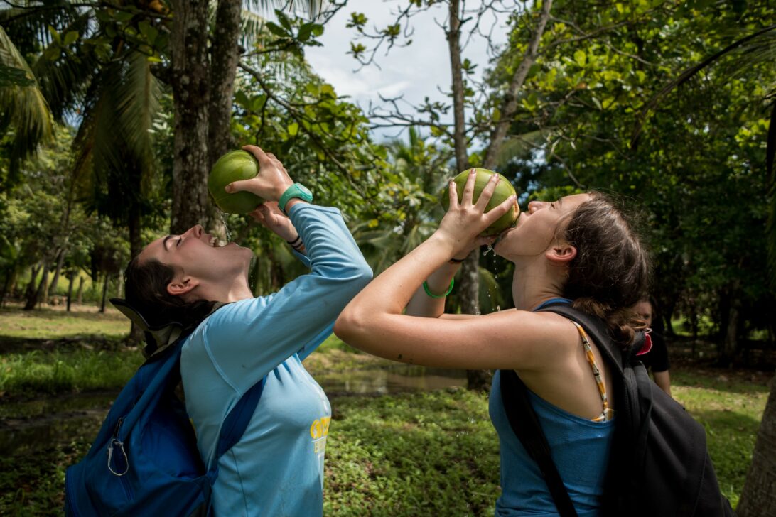 two students drinking out of fresh coconuts in Costa Rica