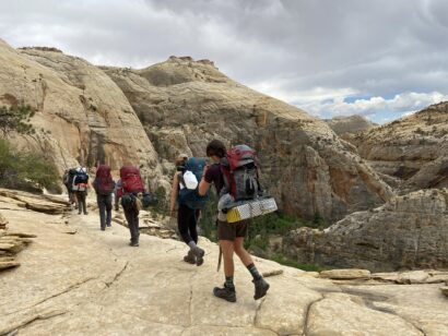 group backpacking through rocky desert terrain
