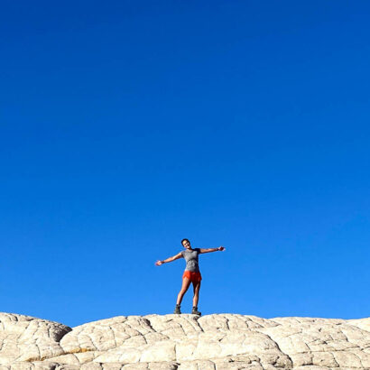 Traveler on top of rocks with arms outstretched