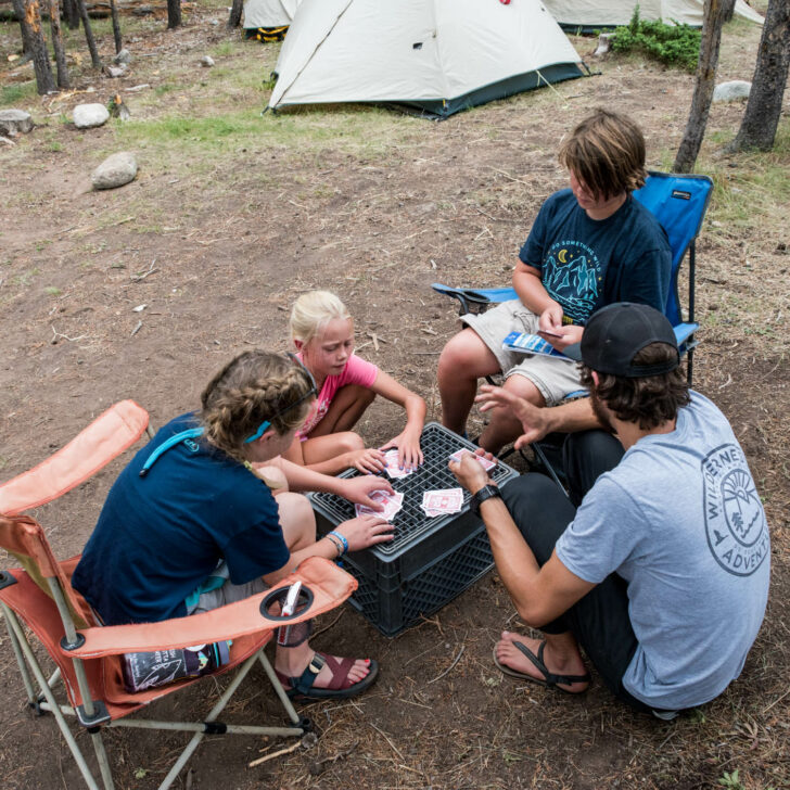 Travelers playing card games at a campsite