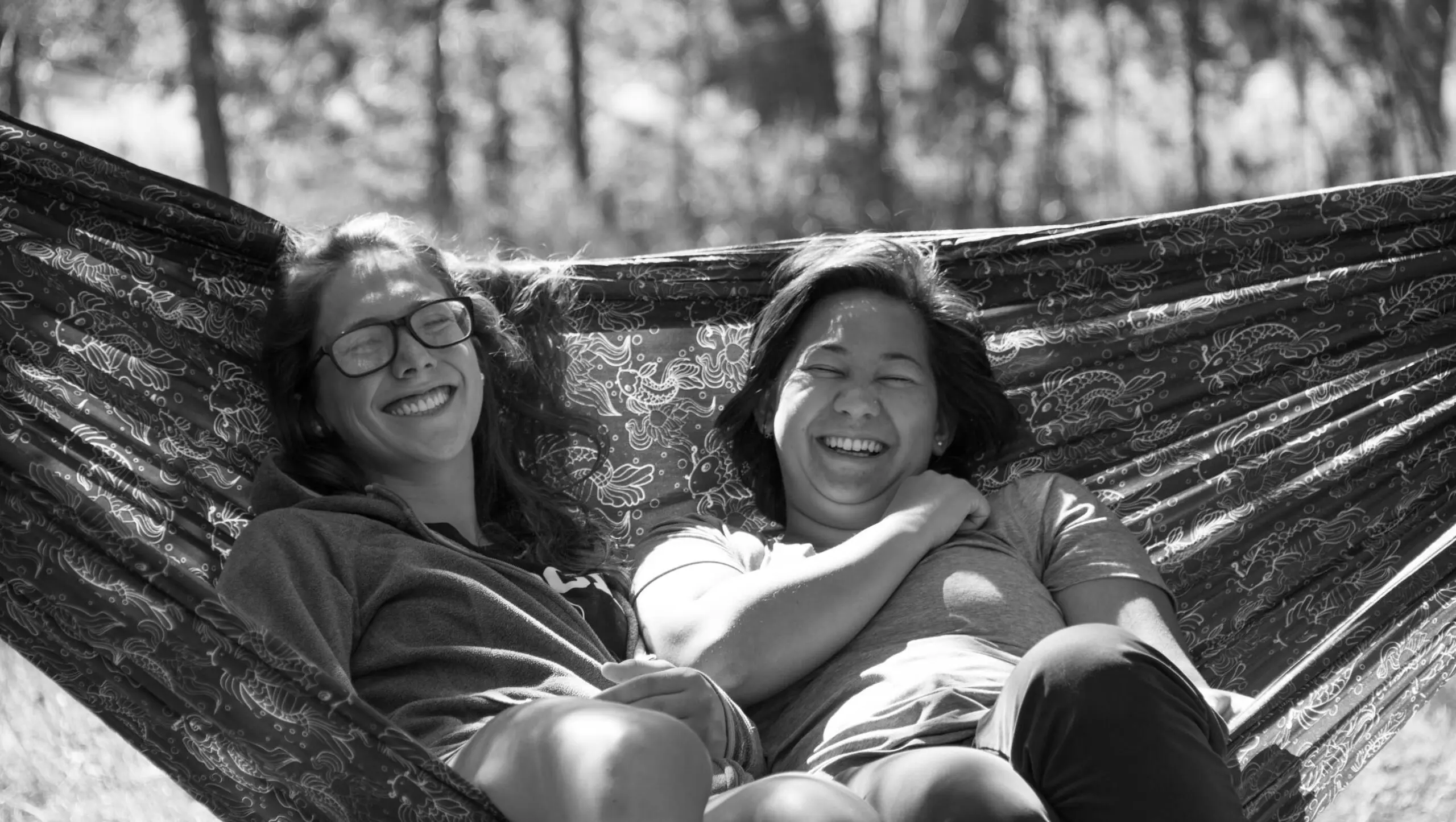 Two girls laughing in a hammock