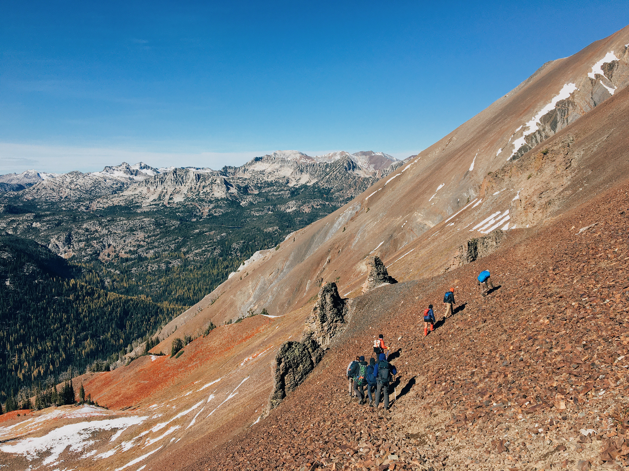 Group of people trekking across a rocky mountainside.