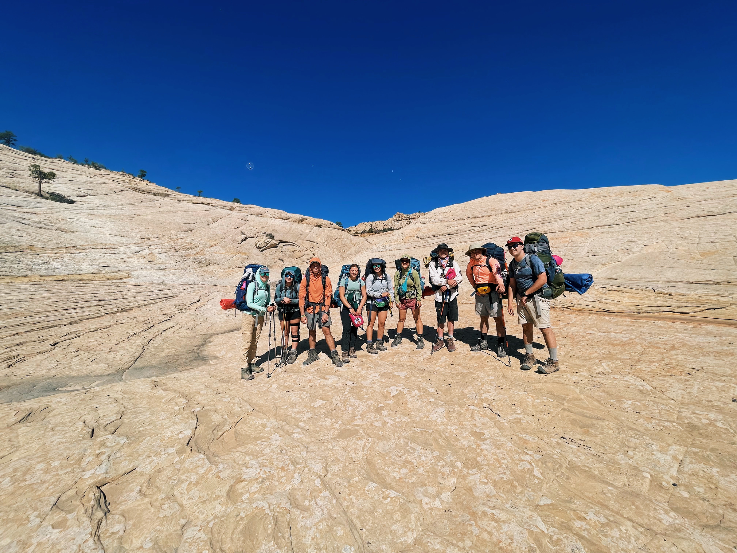 Group of people backpacking in the desert.