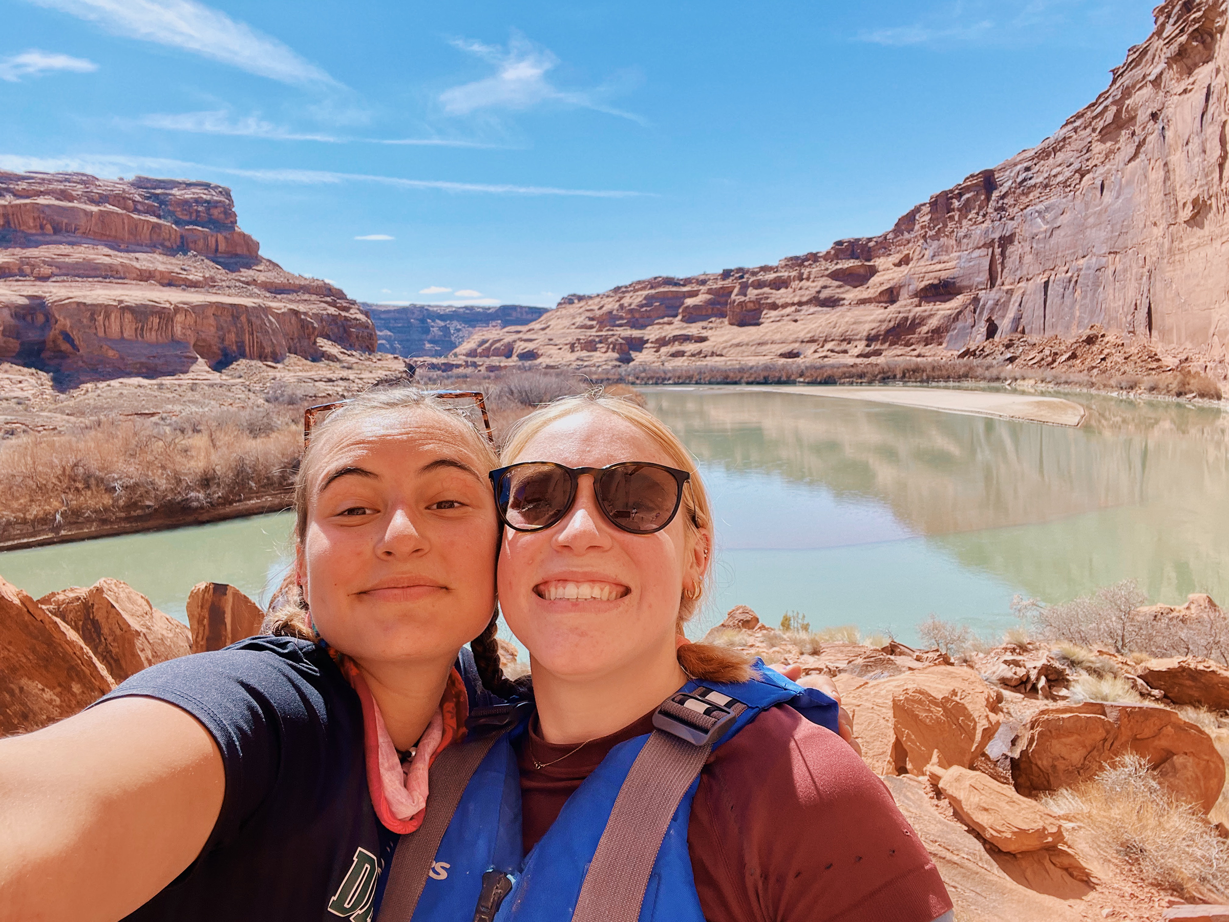 Two people smiling in front of a canyon.