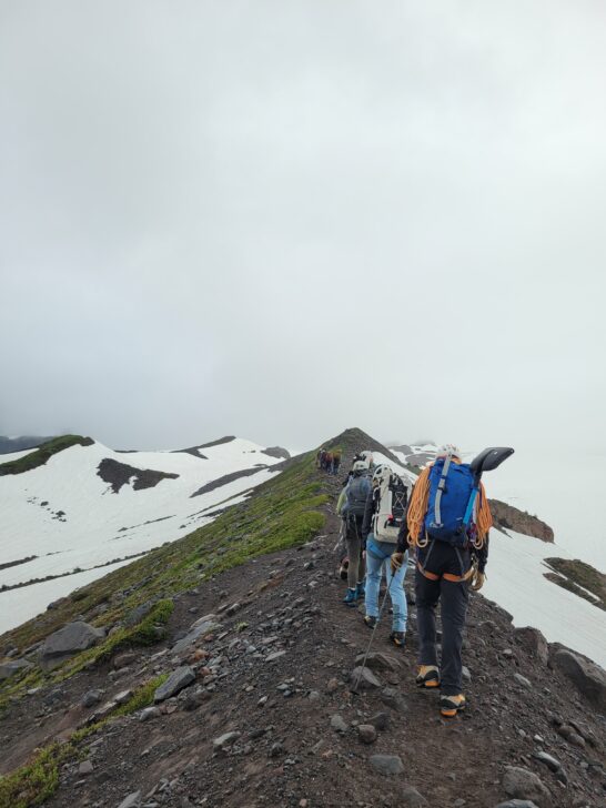 students backpacking along a ridge in the PNW