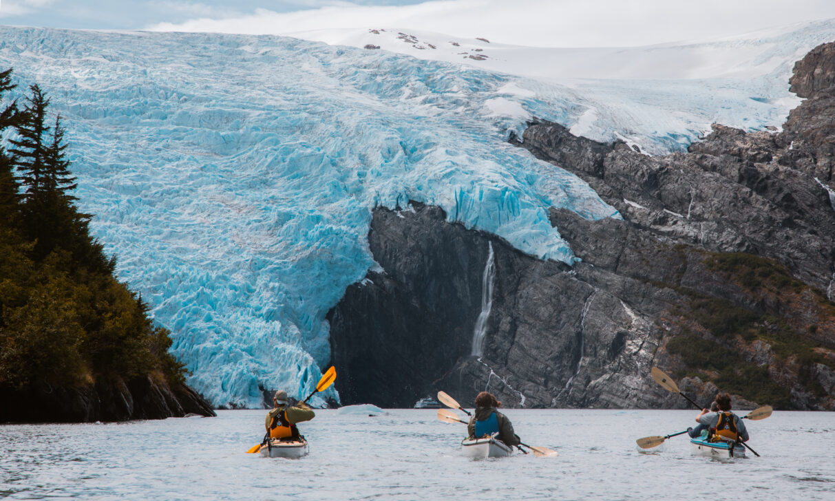 group sea kayaking towards a glacier
