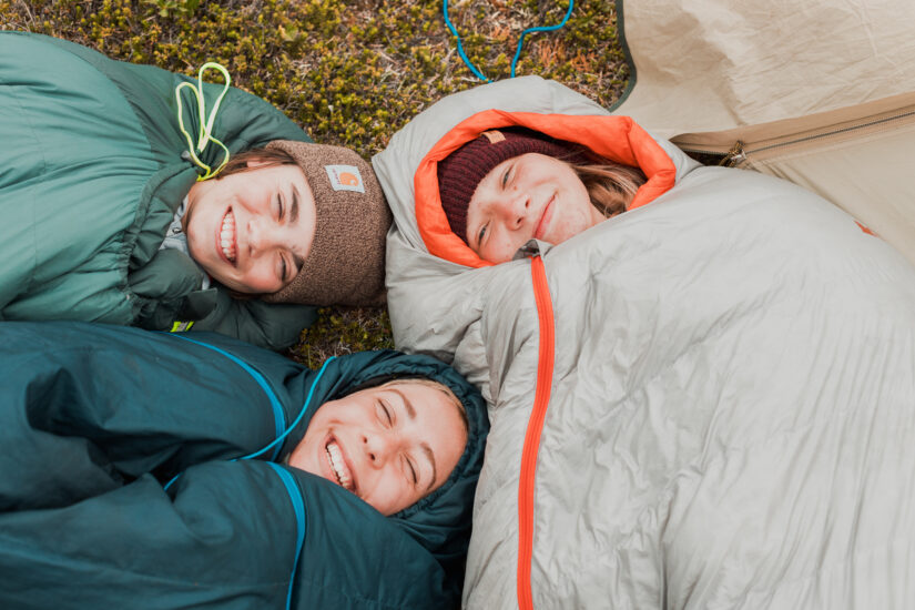 2 students wrapped up in sleeping bags smiling