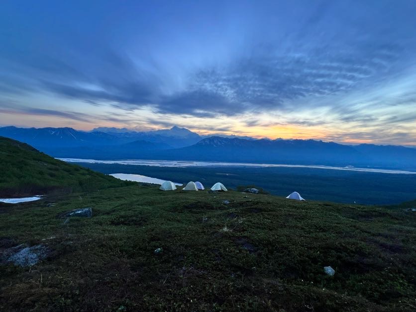 Sunset over peaks and tents in alaska