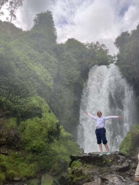 student posing in front of a waterfall