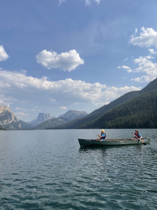 canoe on a lake in wyoming with 2 paddlers