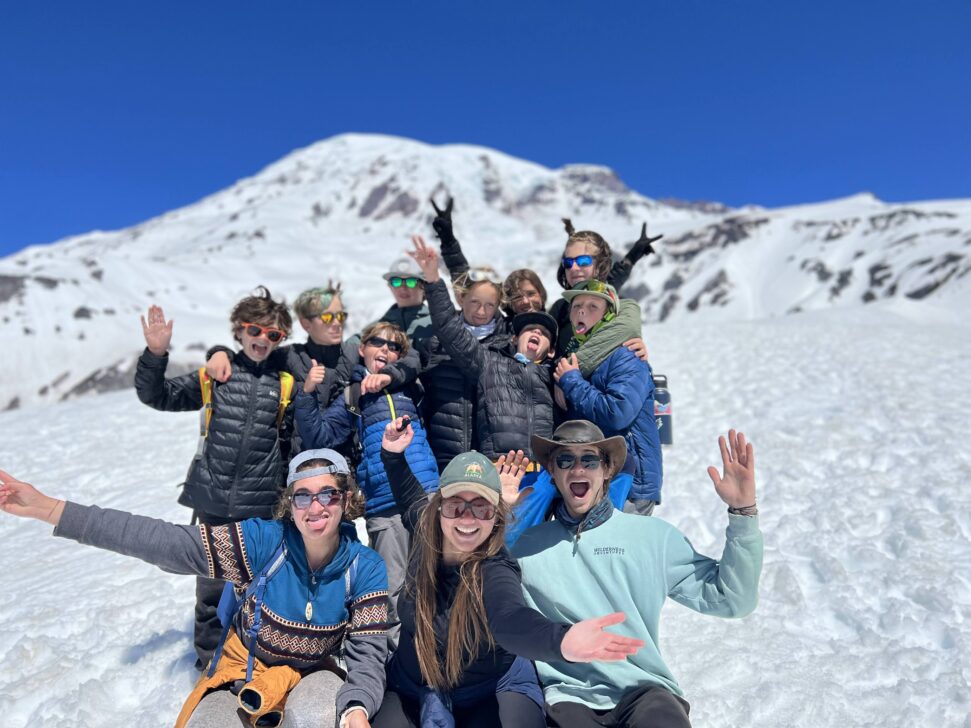 group in front of a snowy mountain all smiling