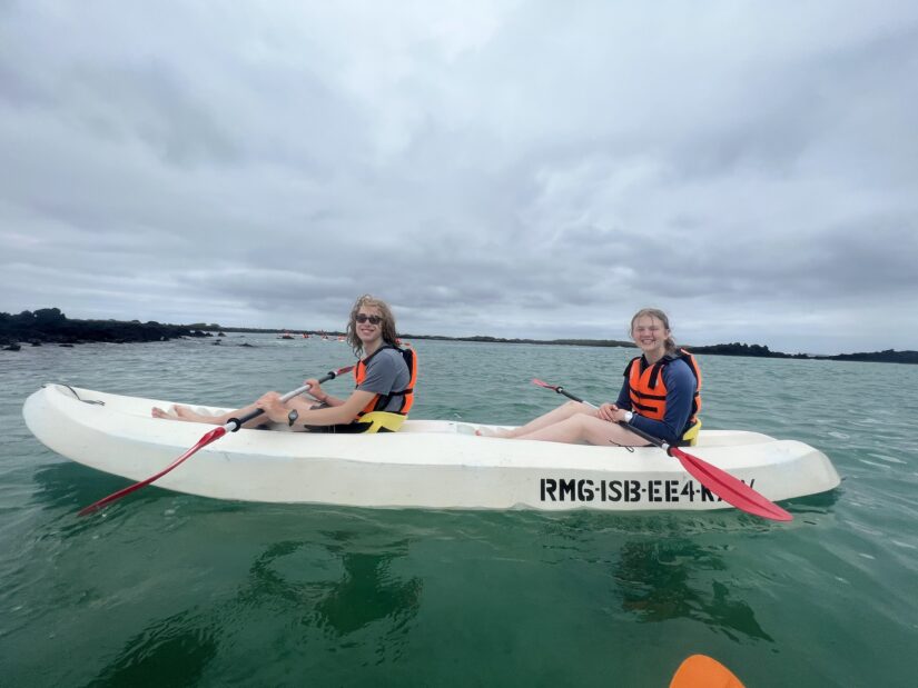 two students in a sea kayak on the ocean