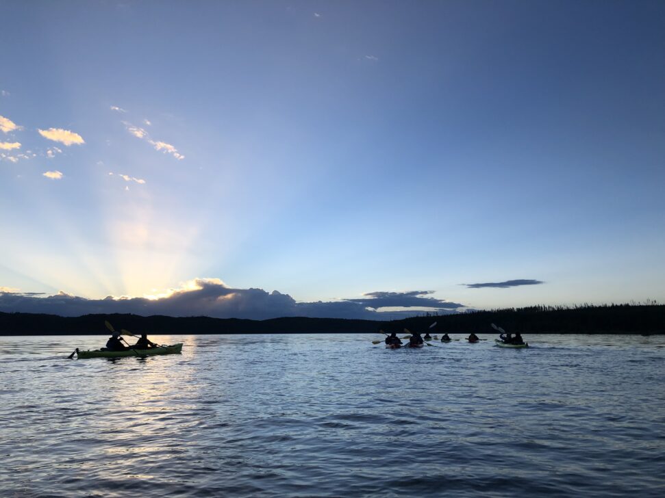 a group of seakayakers on the lake at sunrise