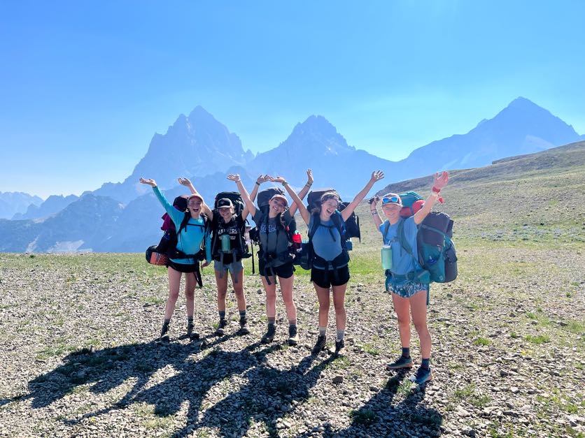 a groups poses in front of the Tetons