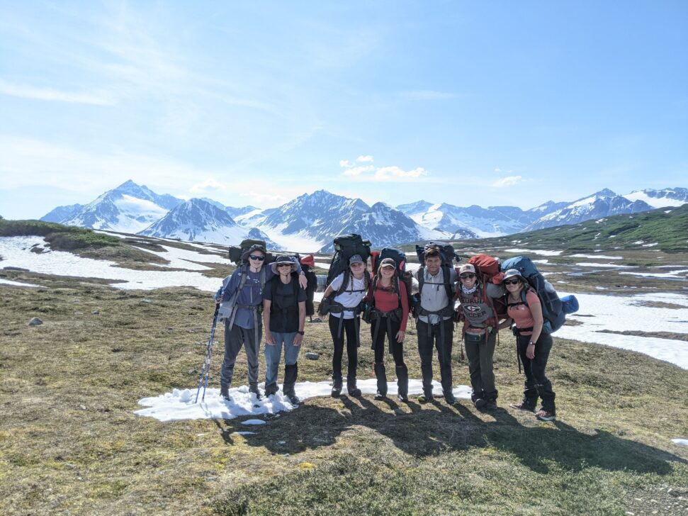 A group of backpackers stand together in Alaska