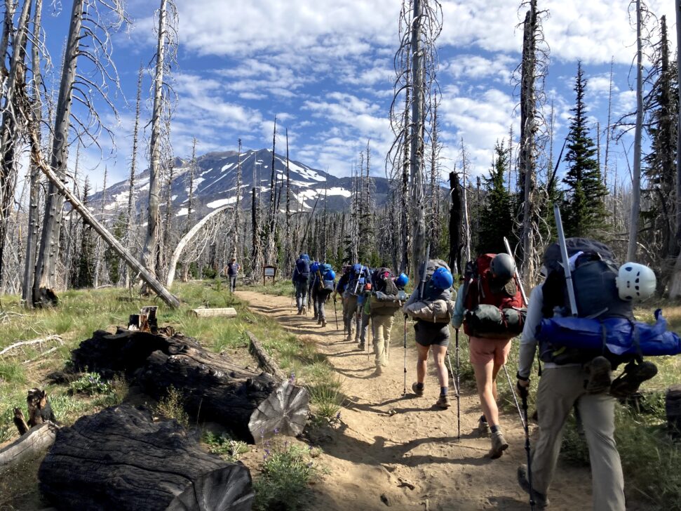 Group backpacking with a mountain in the backgroun