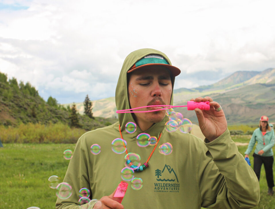 Person blowing bubbles in the mountains.
