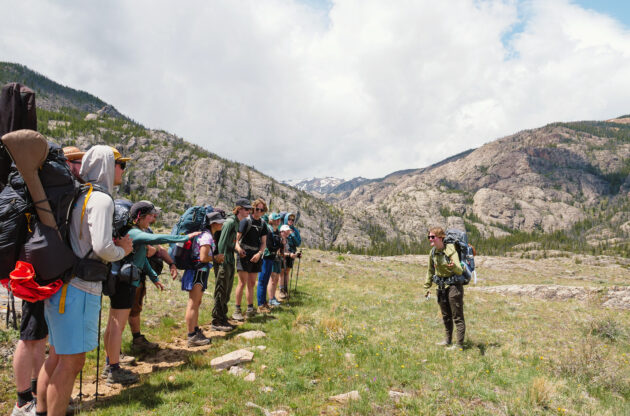person talking to a group of hikers