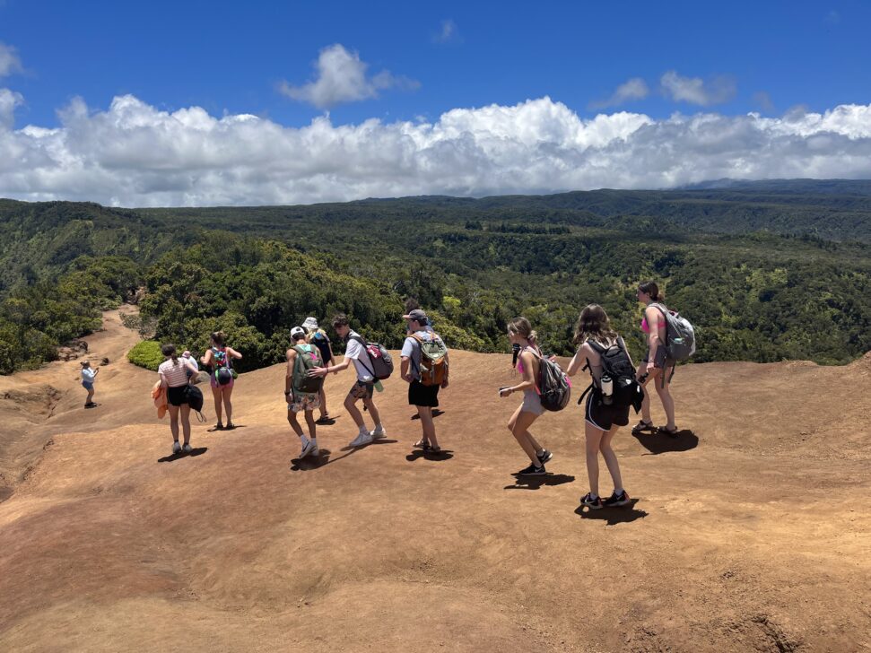 Group hiking on a dirt trail in Hawaii