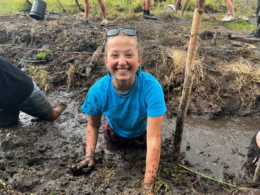 Smiling erson in mud doing community service in Hawaii