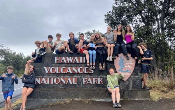 group of students on the Hawaii Volcanoes National Park Sign