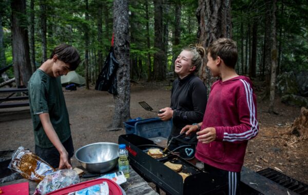 Campers cooking and laughing. 