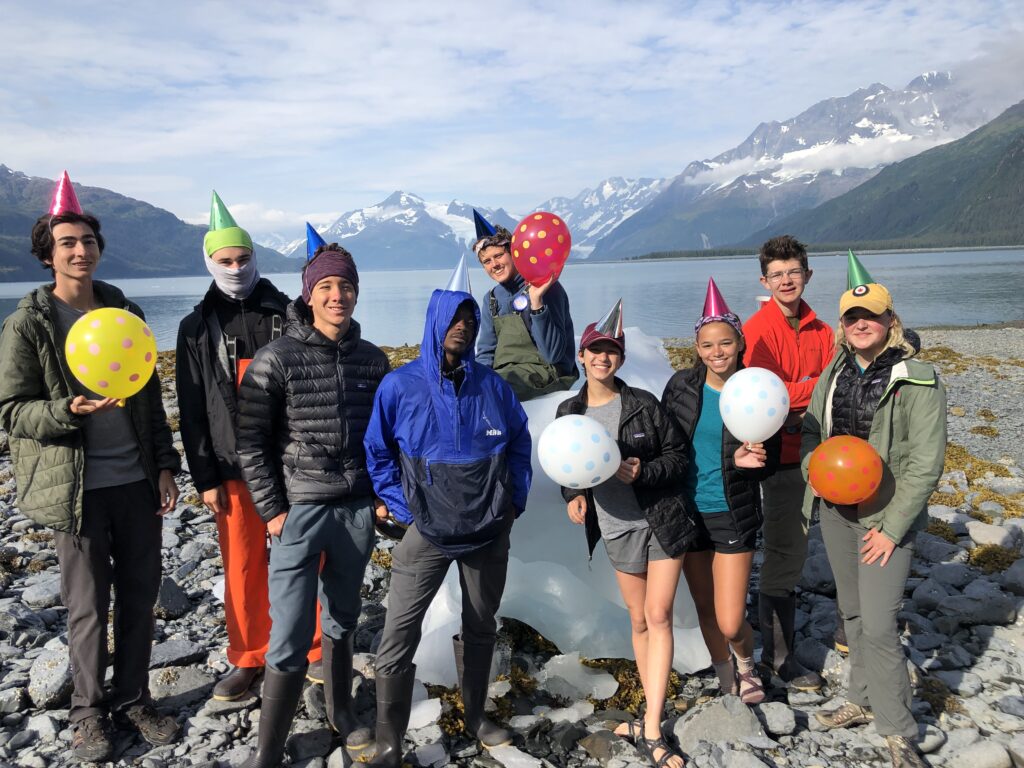 Group of students by the ocean in Alaska celebrating a birthday.
