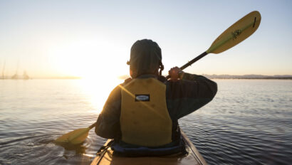 Person paddling on Yellowstone Lake in the sunrise.