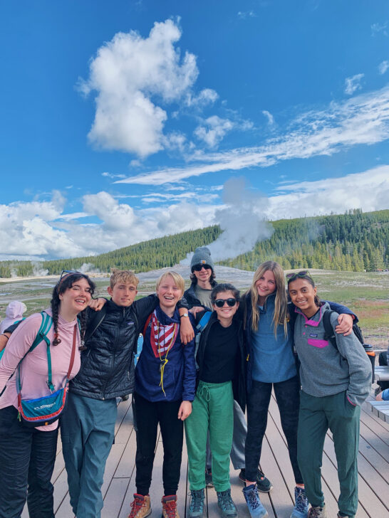 Group of students infront of geysers in Yellowstone National Park.